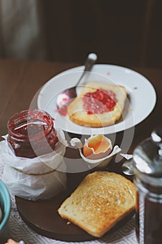 Country cottage kitchen with breakfast on wooden table.