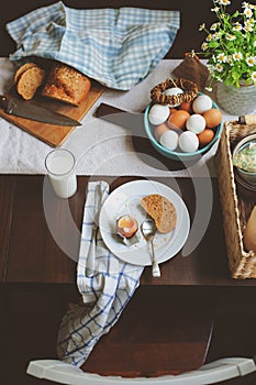Country cottage kitchen with breakfast on wooden table.
