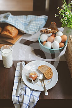 Country cottage kitchen with breakfast on wooden table.