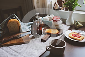 Country cottage kitchen with breakfast on wooden table.