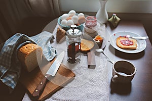 Country cottage kitchen with breakfast on wooden table.