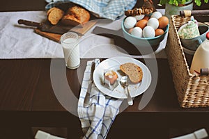 Country cottage kitchen with breakfast on wooden table.