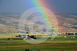 Country farm, field and rainbow