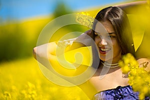 Country girl in a good mood walks in a rape field