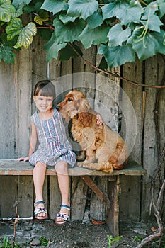 Country girl sitting on a bench with her dog under vine. wooden