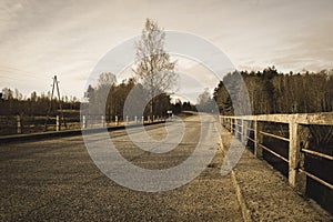 country gravel road with old and broken asphalt - vintage retro look