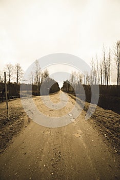 country gravel road with old and broken asphalt - vintage retro look