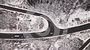 Country highway with a fork and moving cars in winter, aerial view.