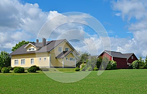 Country house in the meadow and farm buildings