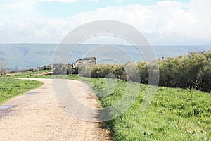 Country house or rural house by the road. Background of field, mountains and sky. Green pea field and blue sky in the