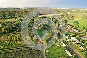 Country houses in the countryside. Aerial view of roofs of green field with rural homes. Village with wooden home. Suburban house