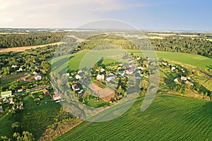 Country houses in the countryside. Aerial view of roofs of green field with rural homes. Village with wooden home. Suburban house