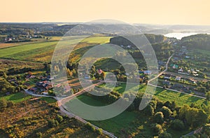 Country houses in the countryside. Aerial view of roofs of green field with rural homes. Village with wooden home. Suburban house