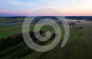 Country houses in the countryside. Aerial view of roofs of green field with rural homes. Village with wooden home. Suburban house