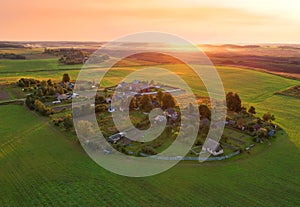 Country houses in the countryside. Aerial view of roofs of green field with rural homes. Village with wooden home. Suburban house