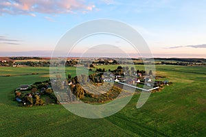 Country houses in the countryside. Aerial view of roofs of green field with rural homes. Village with wooden home. Suburban house