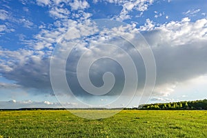 Country landscape. Green field and rain cloud