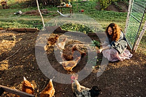 Country life, city woman feeding chickens with fresh grass