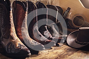 Country music festival live concert concept with acoustic guitar, cowboy hat and three pairs of boots