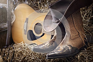 Country music festival live concert or rodeo with cowboy hat guitar and boots in barn photo