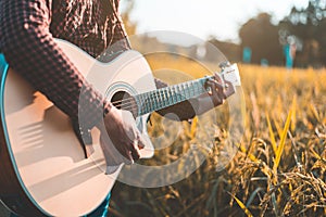 Country music, Man playing acoustic guitar in rice field