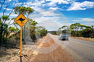 Country outback with yellow kangaroo road sign