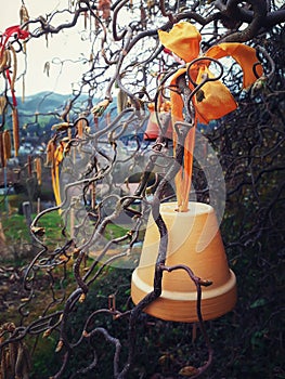 Country outdoors view bell ornament close up hanging on a tree tied with a yellow ribbon