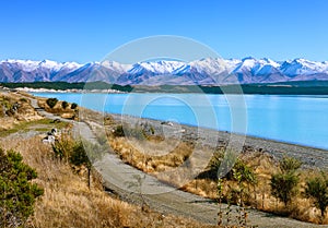 The country road along the Lake Tekapo and snowy mountains in autumn, Canterbury, South Island, New Zealand
