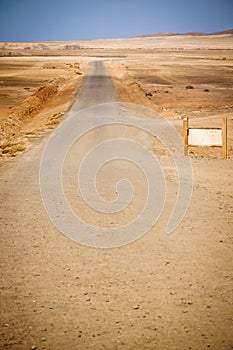 Country road, blank billboard and desert landscape