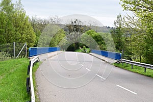 country road crossing the Autobahn with blue side barrier