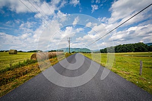 Country road with distant mountains and farm fields in the rural