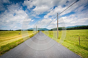 Country road with distant mountains and farm fields in the rural