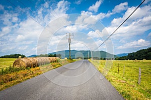 Country road with distant mountains and farm fields in the rural