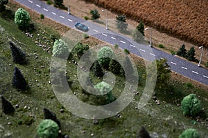 Country road with green trees, car and dry wheat crop field. Agriculture concept