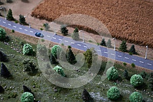 Country road with green trees, car and dry wheat crop field. Agriculture concept