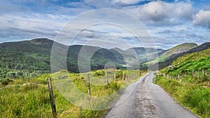 Country road leading to majestic Black Valley with lake and mountain range