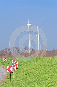 Country Road, meadow and two wind turbines on the blue sky