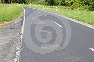 a country road with rather bad repairs of potholes that created further waves