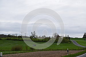 country road in rural Luxembourg, farm on a hill