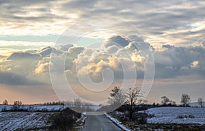 A country road with spectacular clouds above , landscape
