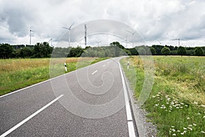 Country road to a wind farm on a cloudy day