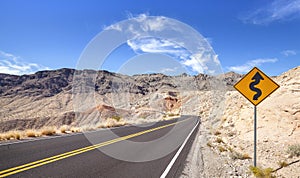 Country road and winding road sign.