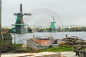 Country sawmill with lumber and old wooden boat on yard in rural Holland