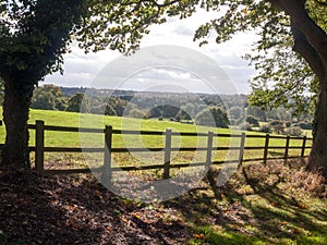 country side open rolling fields below with wooden fence up front