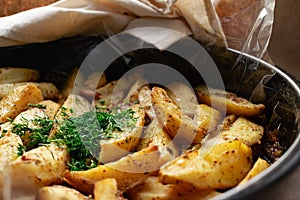 Country-style baked potato wedges, garnished with dill, an aromatic spiced home dish, crispy crust and delicious family food