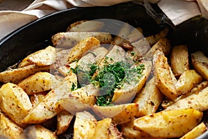 Country-style baked potato wedges, garnished with dill, an aromatic spiced home dish, crispy crust and delicious family food