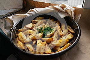 Country-style baked potato wedges, garnished with dill, an aromatic spiced home dish, crispy crust and delicious family food