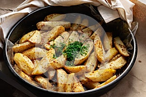 Country-style baked potato wedges, garnished with dill, an aromatic spiced home dish, crispy crust and delicious family food