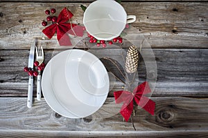 Country style christmas dinner place setting adorned with ornaments.