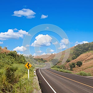 Country winding road sign with blue sky